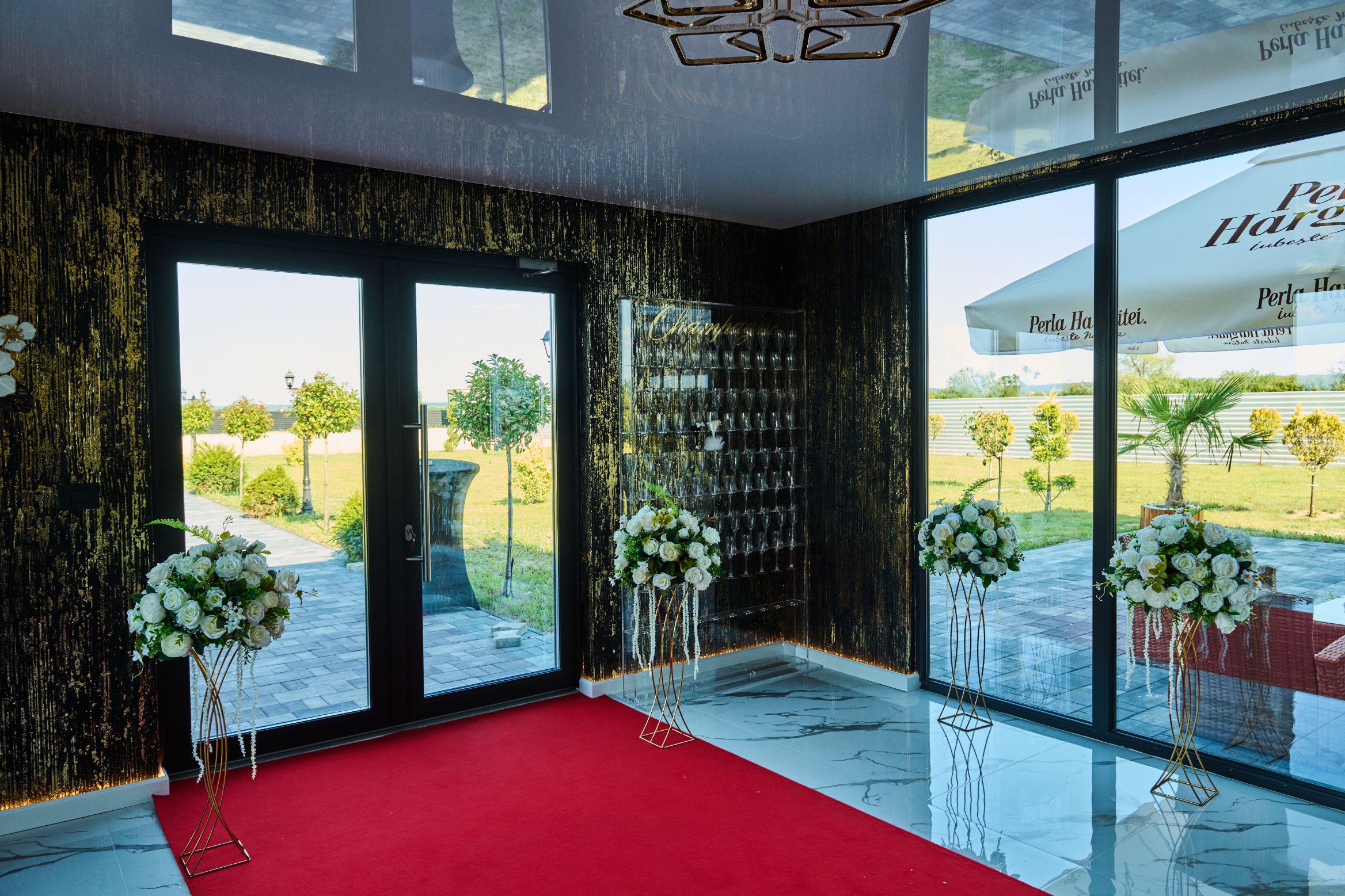 Sala de evenimente cu candelabre aurii și mese verzi