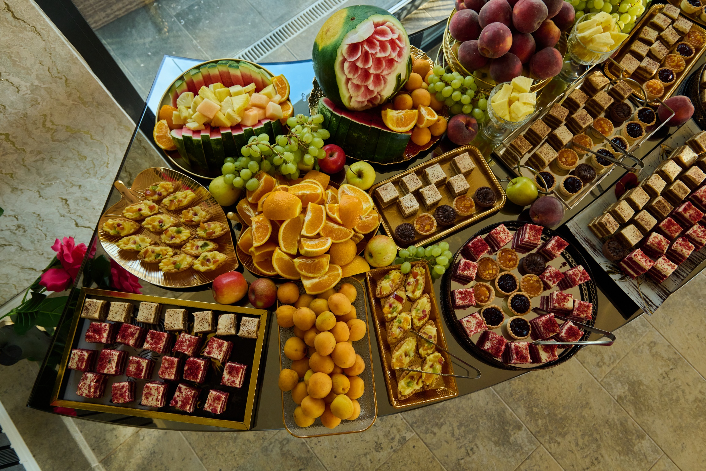 Prăjituri red velvet și tarte cu fructe pe platou
